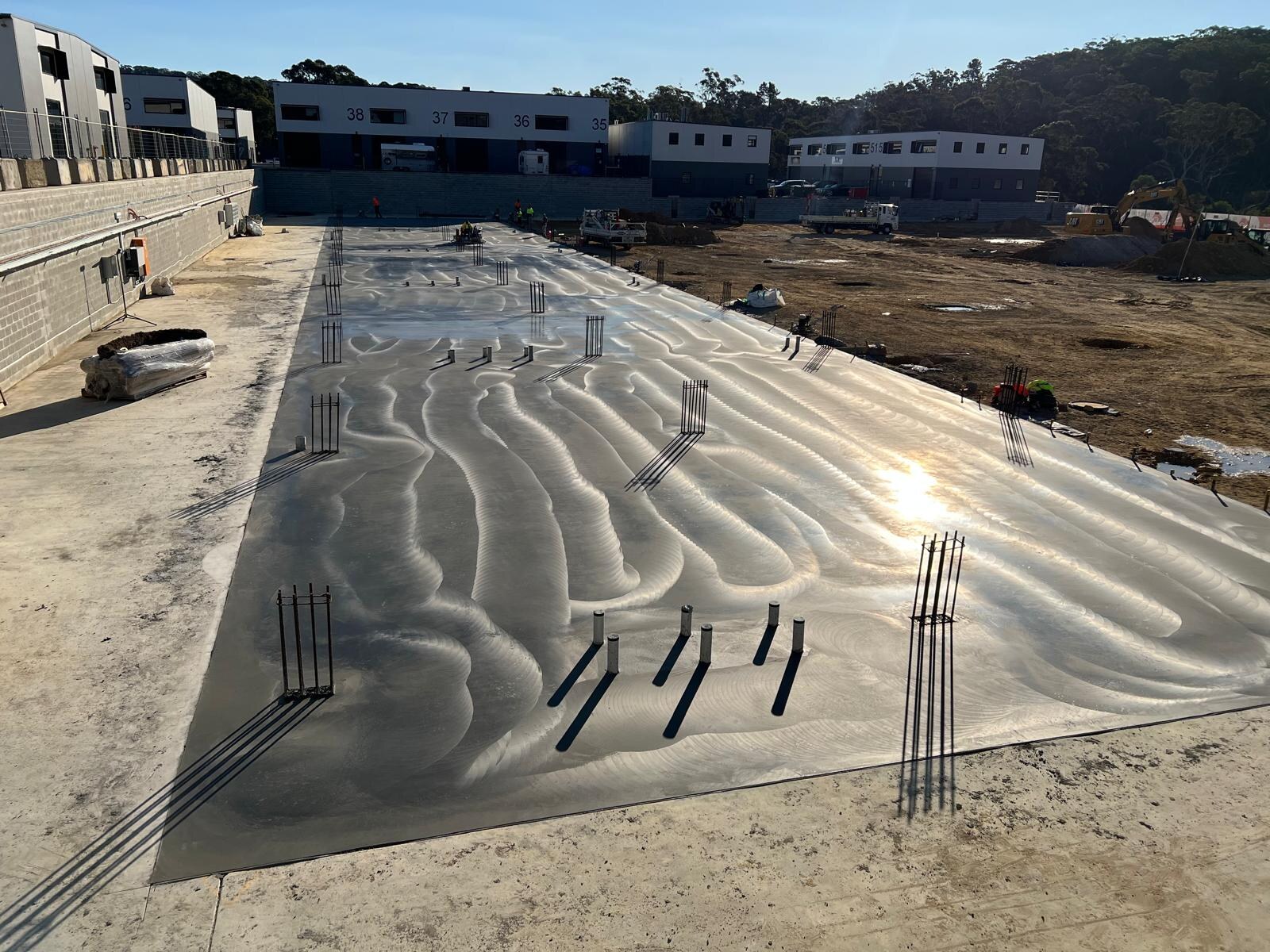 Machine-trowelled finish patterns across a fresh industrial slab