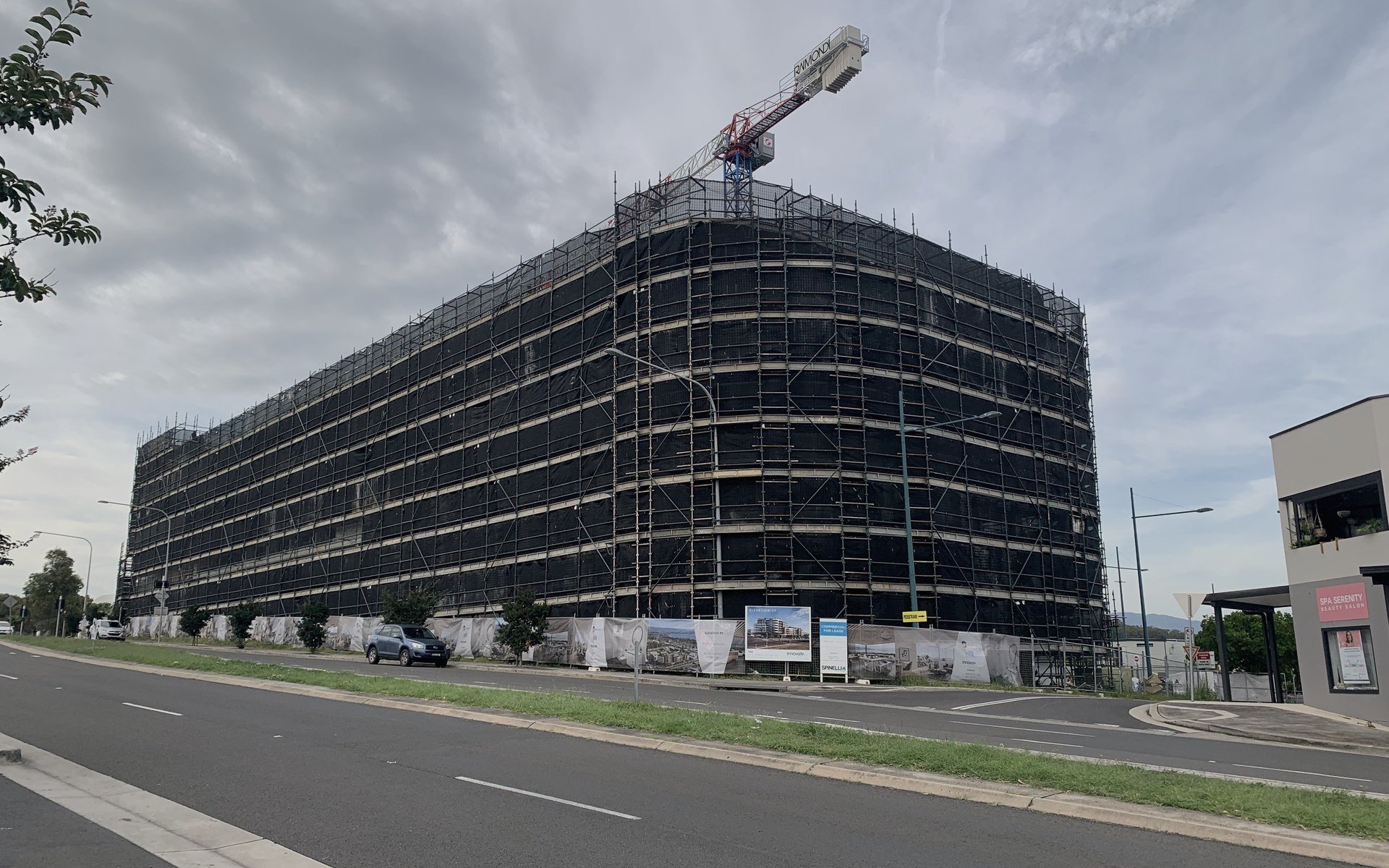 Multi-storey residential apartment block in scaffold under a tower crane